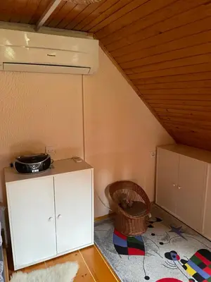a room with a white cabinet in a attic at Vintage Holiday House in Šoštanj