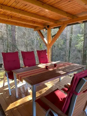a wooden table and chairs on a wooden deck at Vintage Holiday House in Šoštanj