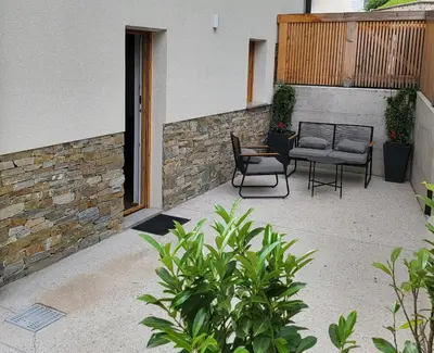 a patio with two chairs and a table at New Apartments Teravila in Rateče