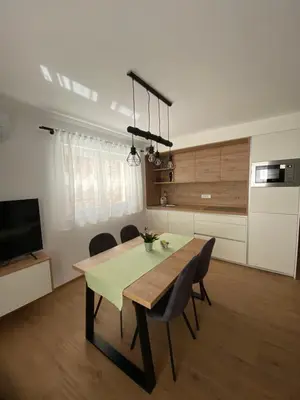 a kitchen and dining room with a table and chairs at New Apartments Teravila in Rateče