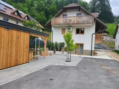 a house with a courtyard with a tree in front of it at New Apartments Teravila in Rateče
