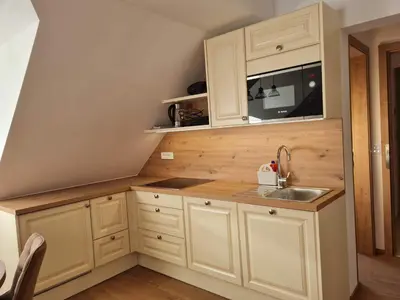 a kitchen with white cabinets and a sink at New Apartments Teravila in Rateče