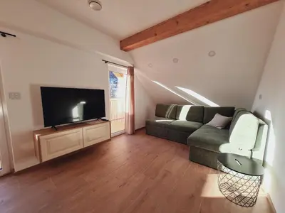 a living room with a couch and a flat screen tv at New Apartments Teravila in Rateče
