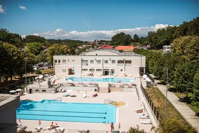 a building with a large swimming pool in front of it at Apartment Center Rogaška - Pubyland in Rogaška Slatina