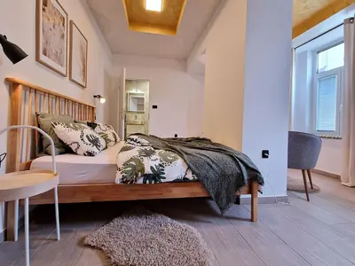 a bedroom with a bed with a wooden headboard at Apartment Center Rogaška - Pubyland in Rogaška Slatina