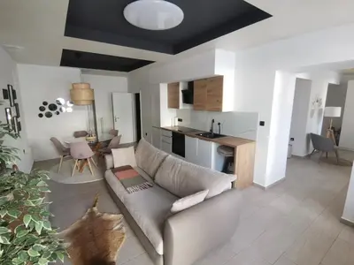 a living room with a couch and a kitchen at Apartment Center Rogaška - Pubyland in Rogaška Slatina