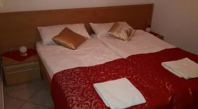 a bedroom with a large bed with red sheets and pillows at Apartma Steles in Stari Trg pri Ložu
