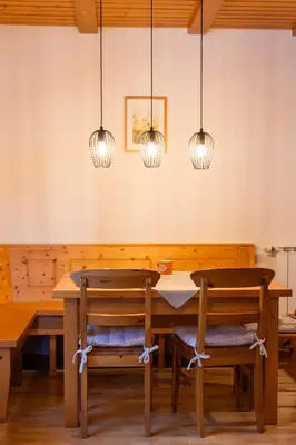 a dining room with a wooden table and lights at Bolfenk Snowflake app in Pohorje
