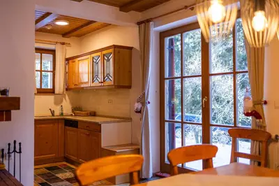 a kitchen with wooden cabinets and a large window at Bolfenk Snowflake app in Pohorje