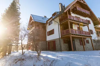 a house in the snow with the sun shining at Bolfenk Snowflake app in Pohorje