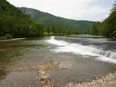 a river with a waterfall in the middle at Madronič family estate - Kolpa river in Stari Trg ob Kolpi