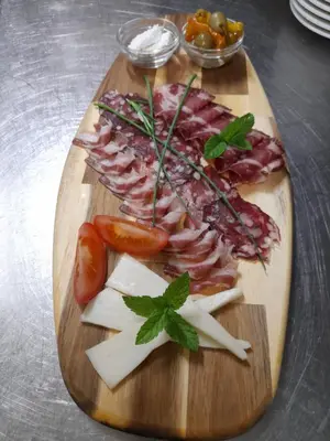 a cutting board with meats and cheese on a table at Madronič family estate - Kolpa river in Stari Trg ob Kolpi