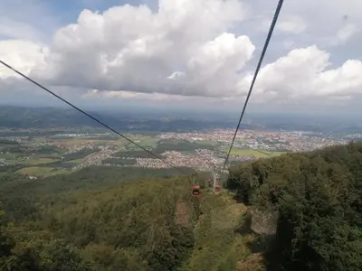 a gondola ride in the sky over a city at Apartment Alpina in Pohorje