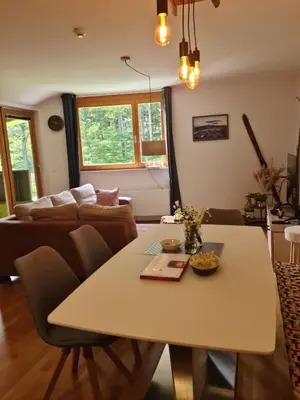a living room with a table and a couch at Apartment Alpina in Pohorje