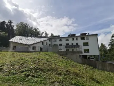 a white house on top of a hill at Apartment Alpina in Pohorje