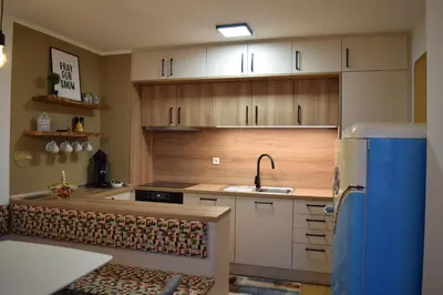 a kitchen with wooden cabinets and a sink at Apartment Alpina in Pohorje