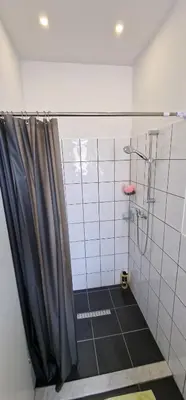 a shower with a black shower curtain in a bathroom at Apartman MURKO P-1 in Brest