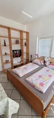 a bedroom with two beds and a tv and shelves at Apartman MURKO P-1 in Brest