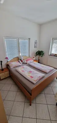 two beds in a bedroom with two windows at Apartman MURKO P-1 in Brest