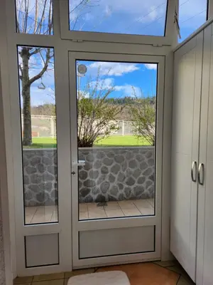 a glass door with a view of a yard at Apartma Nika in Planina