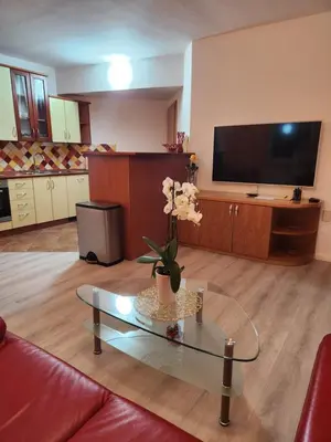 a living room with a vase with flowers on a glass table at Apartma Nika in Planina