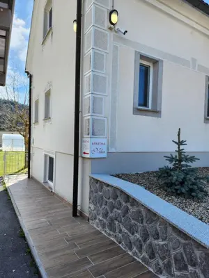 a building with a sign on the side of it at Apartma Nika in Planina