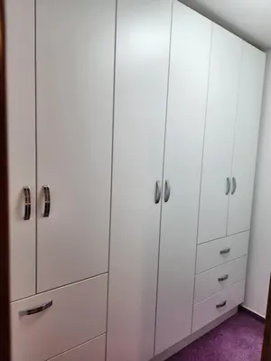 a closet with white cabinets and purple carpet at Apartma Nika in Planina