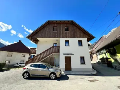 a small car parked in front of a house at APARTMA ALMA in Bovec