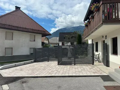 a patio with a black fence next to a building at APARTMA ALMA in Bovec
