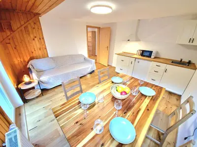 a room with a table and chairs and a kitchen at Bella Bela Apartments 23 in Bled