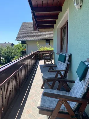 a balcony with two lounge chairs on a house at La casa verde in Bled-Rečica