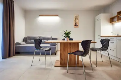 a living room with a table and chairs and a couch at Posestvo Rouna - winery and apartments in Vipava
