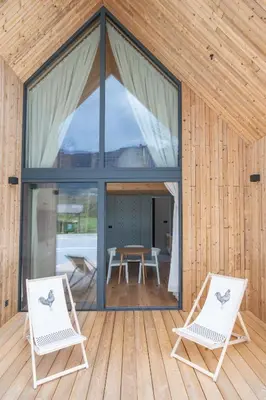 two chairs on the deck of a wooden house at Cabino - Fresh Air Resort in Bovec
