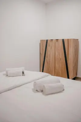 two white towels on a bed in a room at Chalet HerMes arT in Idrija