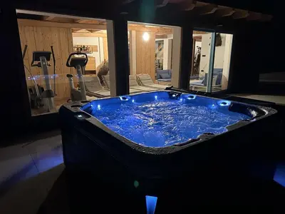 a large blue tub in a gym with exercise equipment at Chalet HerMes arT in Idrija