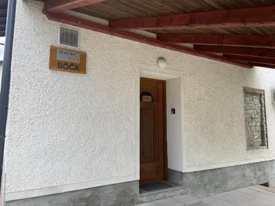 a sign on the side of a building with a door at Apartmaji SOČA in Most na Soči