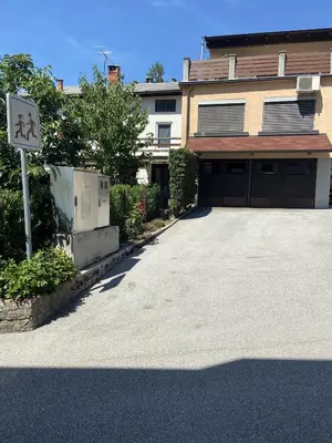 a building with a garage with a sign in front of it at Apartmaji SOČA in Most na Soči