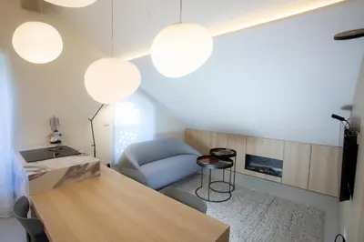 a living room with a table and a blue chair at Studio Vilawin Kranjska Gora in Kranjska Gora