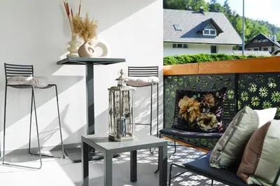 a patio with a fireplace and a table and chairs at Studio Vilawin Kranjska Gora in Kranjska Gora