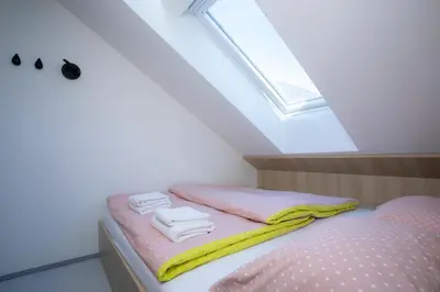 a bedroom with a bed with pink and yellow towels at Studio Vilawin Kranjska Gora in Kranjska Gora