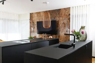 a kitchen with a black counter and a sink at Studio Vilawin Kranjska Gora in Kranjska Gora