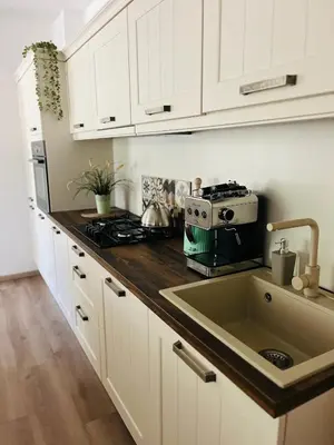 a kitchen with a sink and a stove and white cabinets at Apartment Country House Zaton in Tišina