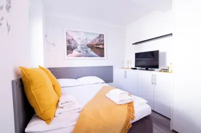a bedroom with a bed with a yellow blanket on it at Bled Lake Apartment House in Bled