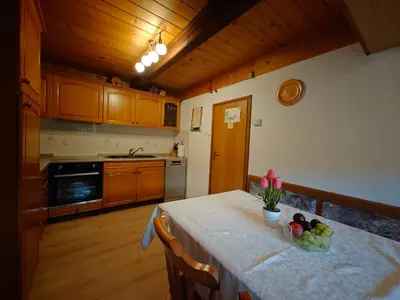 a kitchen with a table with a bowl of fruit on it at Cottage Zoja in Bohinjska Bistrica