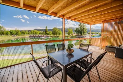 a table and chairs on a deck with a view at DELUXE Lake View Mobile Homes with Thermal Riviera Tickets in Čatež ob Savi