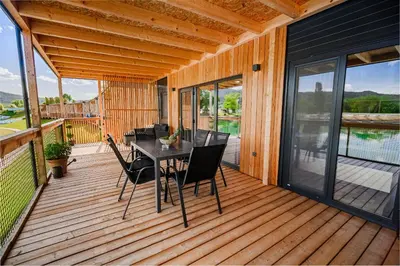 a wooden deck with a table and chairs on it at DELUXE Lake View Mobile Homes with Thermal Riviera Tickets in Čatež ob Savi
