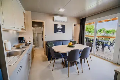 a kitchen and dining room with a table and chairs at DELUXE Lake View Mobile Homes with Thermal Riviera Tickets in Čatež ob Savi