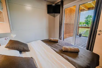 a bedroom with a bed with two towels on it at DELUXE Lake View Mobile Homes with Thermal Riviera Tickets in Čatež ob Savi