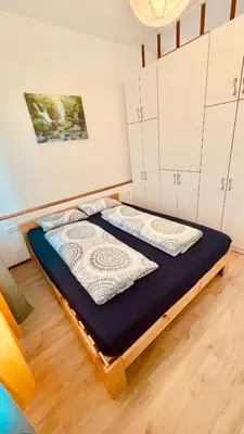 a bed in a room with white cabinets at Blue Sun in Ljubljana