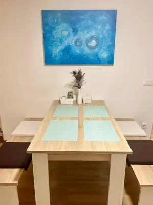 a table in a room with a painting on the wall at Blue Sun in Ljubljana